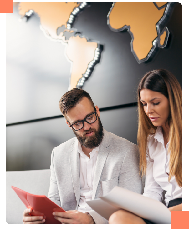 team-stragegy Male and Female business people working on strategy behind a world map